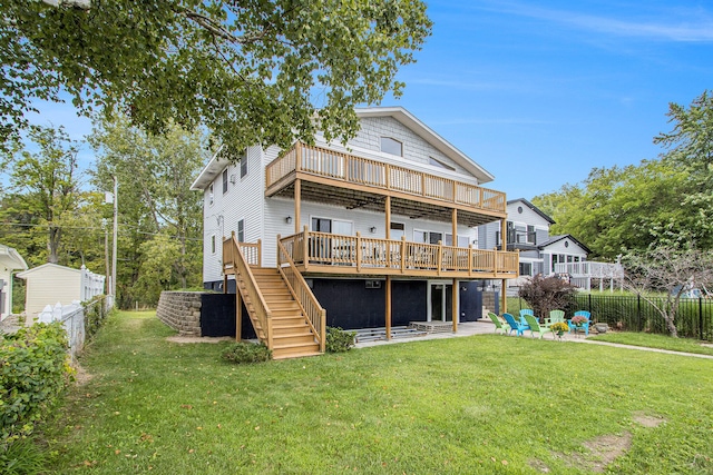 back of house featuring a deck, a patio area, and a lawn