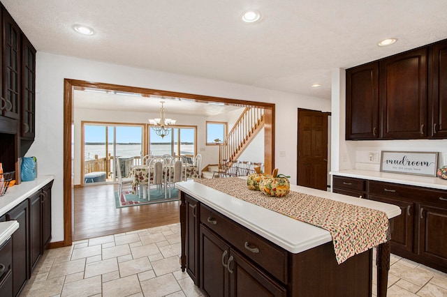 kitchen featuring a center island, hanging light fixtures, a chandelier, light hardwood / wood-style floors, and a water view