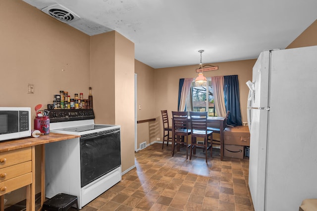 kitchen featuring decorative light fixtures, wood counters, and white appliances