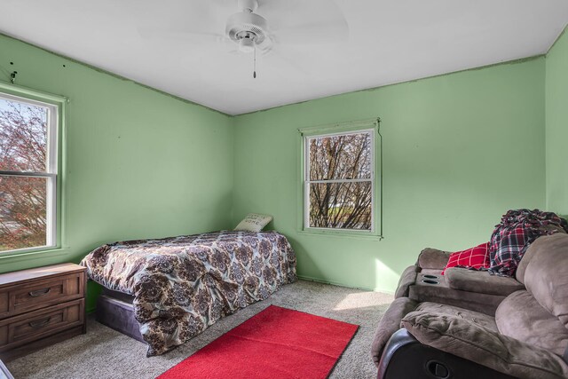 bedroom featuring carpet, multiple windows, and ceiling fan