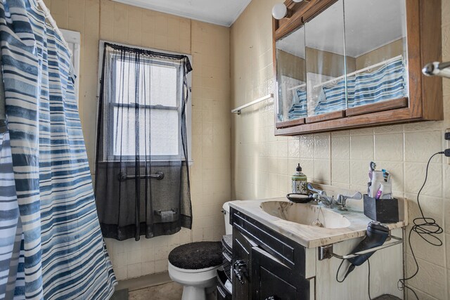 bathroom with vanity, decorative backsplash, toilet, tile walls, and walk in shower