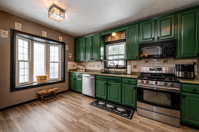 kitchen with stainless steel appliances, a wealth of natural light, light hardwood / wood-style floors, and sink