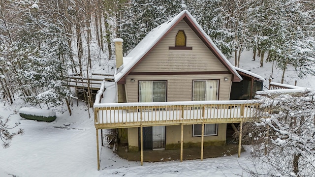 snow covered rear of property featuring a wooden deck