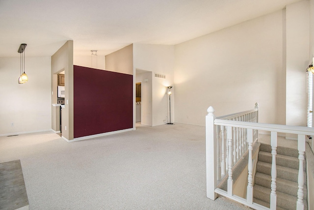 corridor featuring carpet floors and high vaulted ceiling