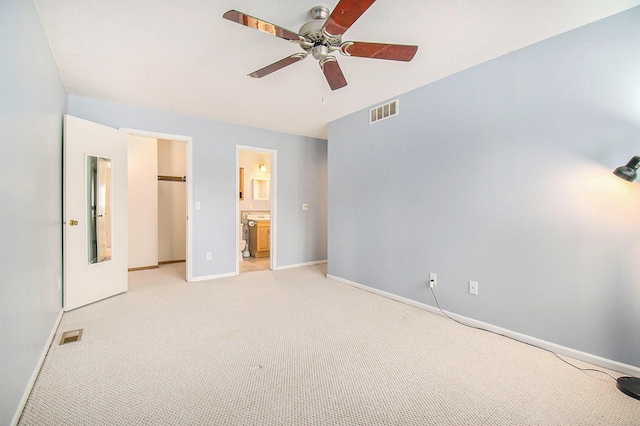 unfurnished bedroom with ensuite bathroom, ceiling fan, and light colored carpet