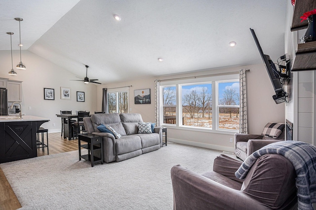 living room featuring a wealth of natural light, vaulted ceiling, light hardwood / wood-style floors, and ceiling fan