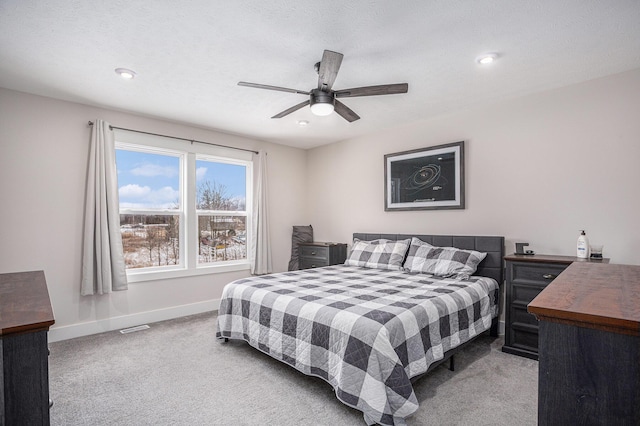 carpeted bedroom featuring a textured ceiling and ceiling fan