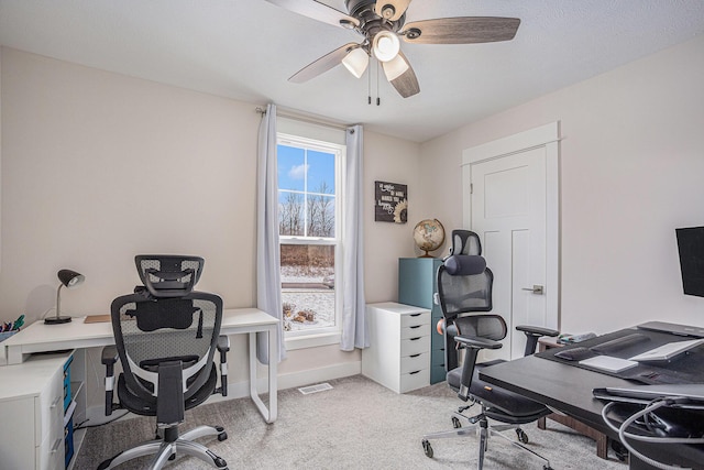 carpeted office space featuring ceiling fan