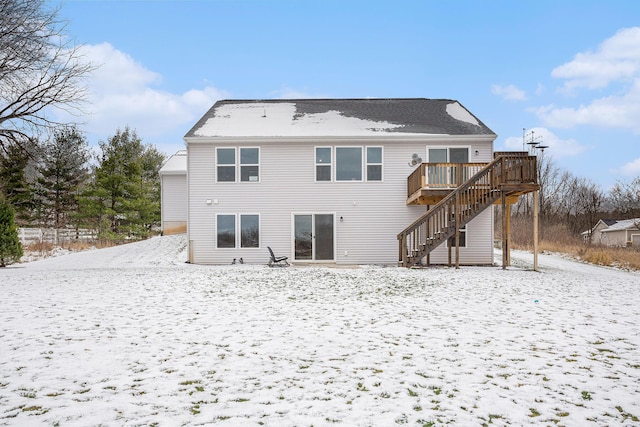 snow covered house with a wooden deck