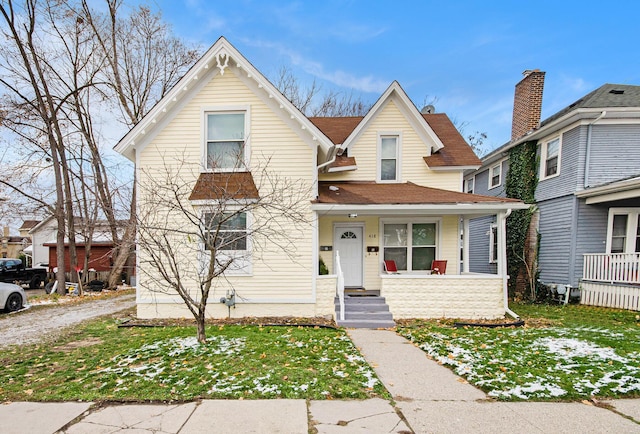 view of front of home with covered porch and a front lawn