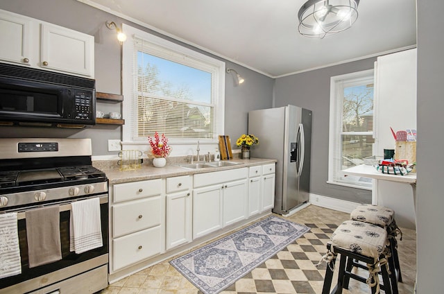 kitchen featuring stainless steel appliances, white cabinetry, crown molding, and sink