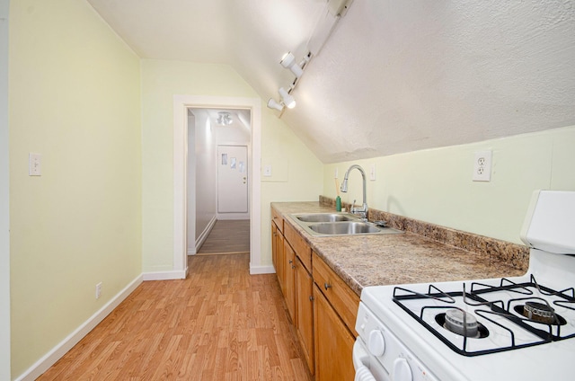 kitchen with sink, light hardwood / wood-style flooring, white range with gas stovetop, a textured ceiling, and vaulted ceiling