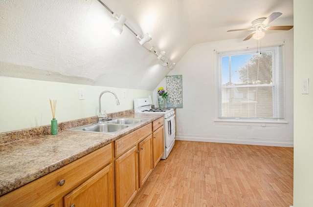 kitchen featuring lofted ceiling, sink, ceiling fan, light wood-type flooring, and white range oven