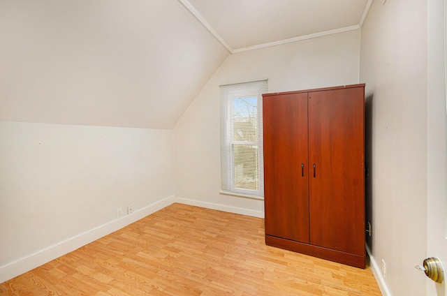 additional living space featuring vaulted ceiling and light hardwood / wood-style flooring