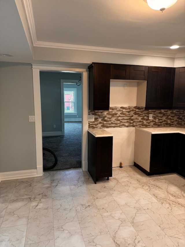 kitchen with decorative backsplash, dark brown cabinets, and ornamental molding