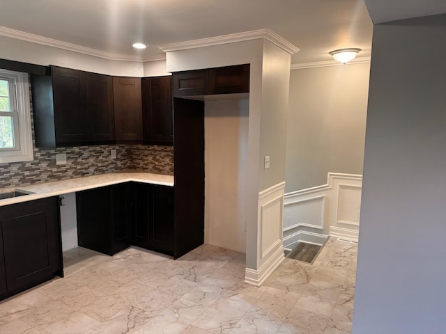 kitchen with decorative backsplash, dark brown cabinets, ornamental molding, and sink