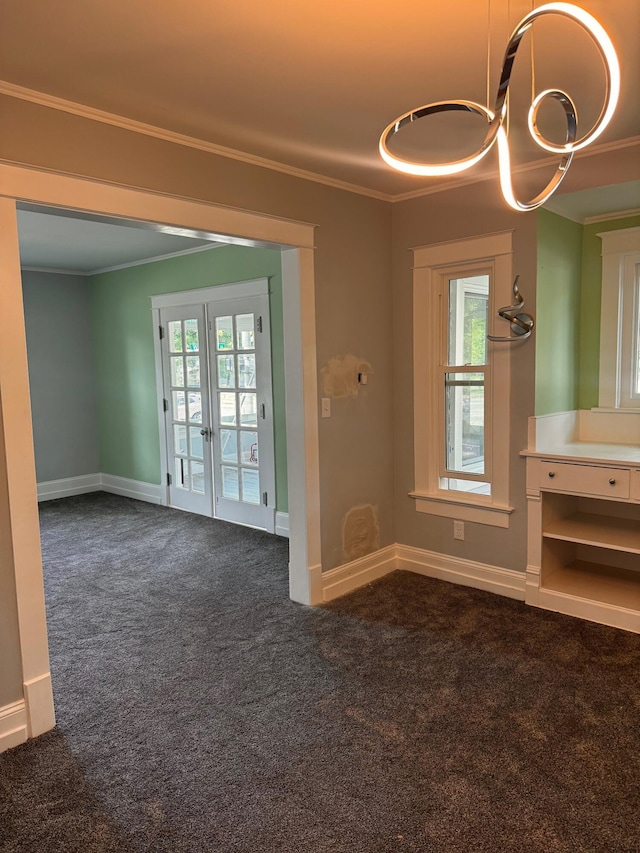 empty room with crown molding, a healthy amount of sunlight, and dark carpet