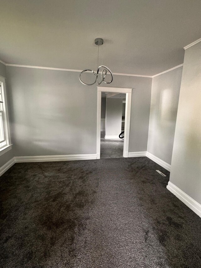 unfurnished dining area featuring dark colored carpet and crown molding