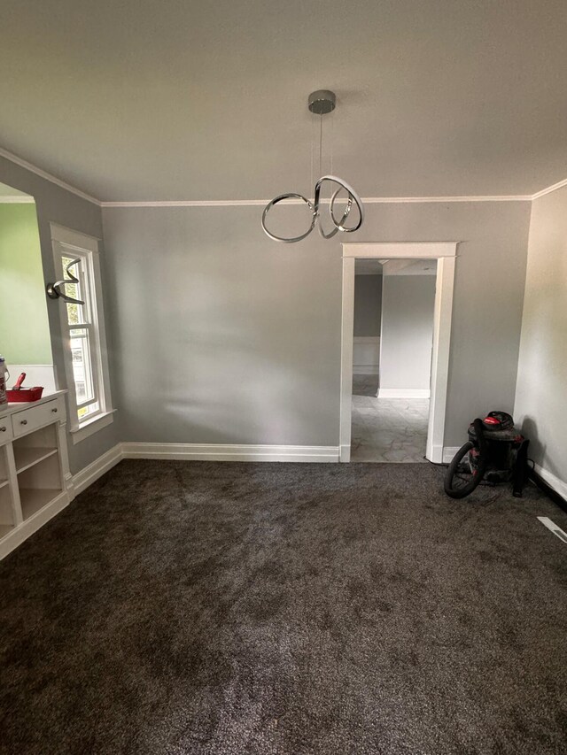 spare room with carpet, ornamental molding, and a chandelier