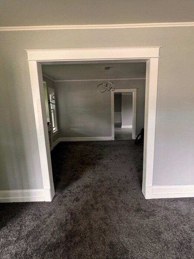 corridor featuring dark carpet and crown molding