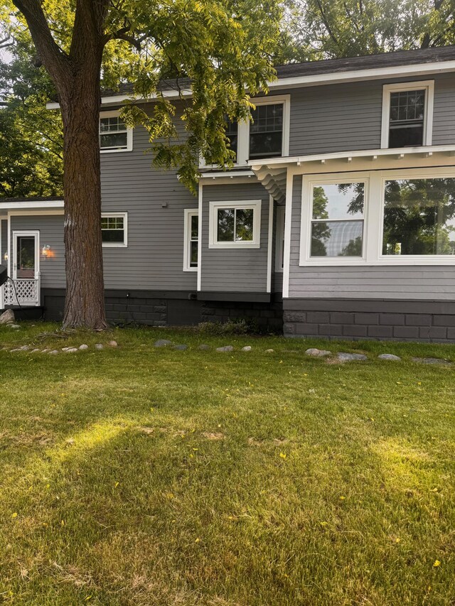 rear view of property featuring a yard