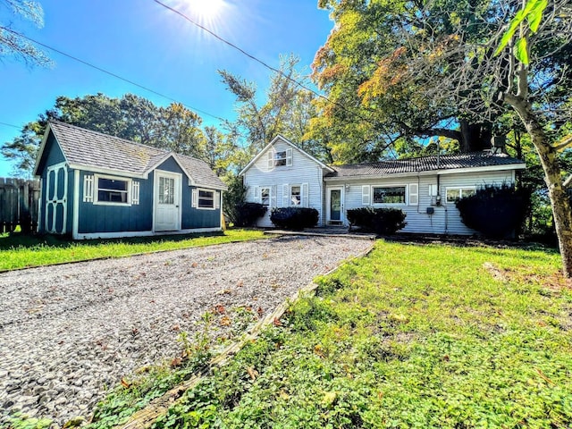 view of front of house with an outbuilding and a front lawn