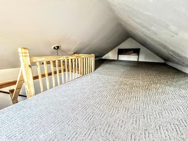 additional living space with carpet flooring and lofted ceiling