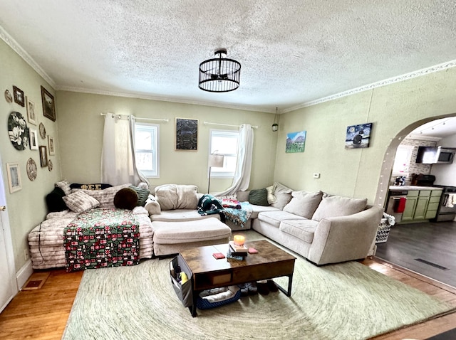 living room featuring hardwood / wood-style floors, an inviting chandelier, crown molding, and a textured ceiling