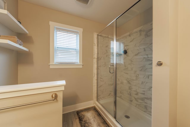 bathroom with an enclosed shower and hardwood / wood-style flooring