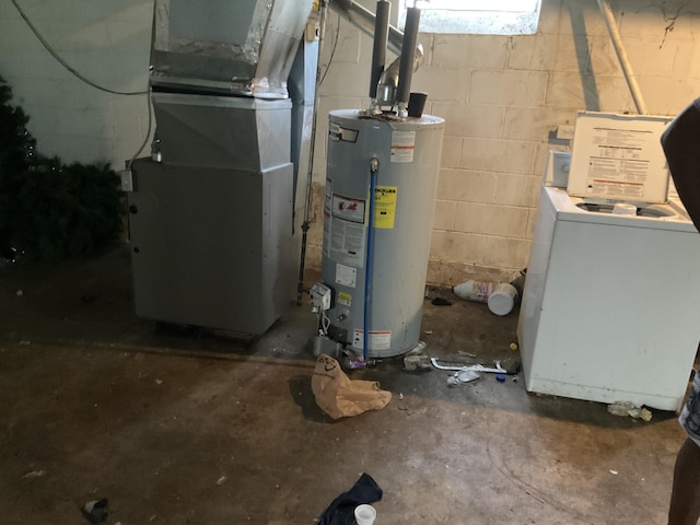 utility room with heating unit, water heater, and washer / dryer