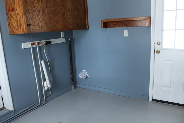 clothes washing area with cabinets