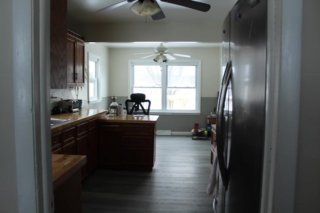 kitchen featuring stainless steel fridge, hardwood / wood-style floors, and kitchen peninsula