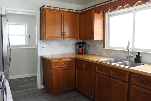 kitchen featuring sink, stainless steel fridge, decorative backsplash, and dark wood-type flooring