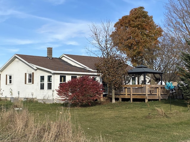 back of house featuring a gazebo and a lawn