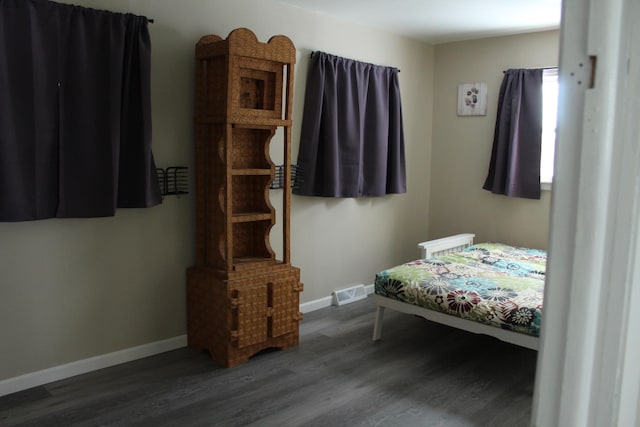 bedroom with dark wood-type flooring