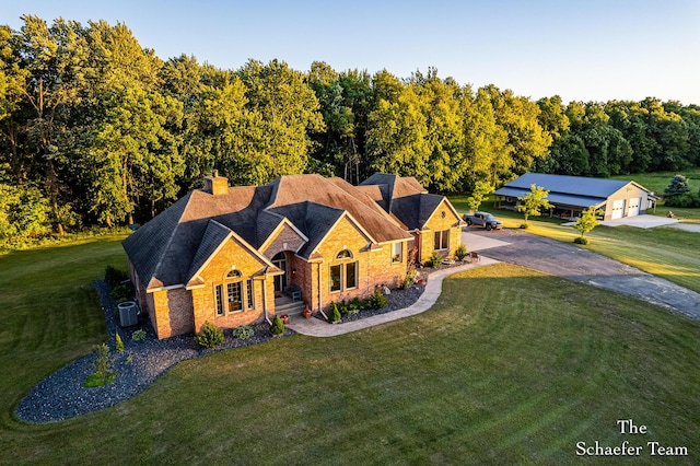 view of front facade featuring central AC unit, a garage, and a front lawn