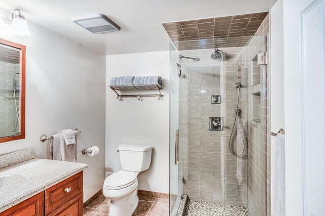 bathroom with walk in shower, tile patterned flooring, vanity, and toilet