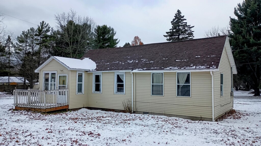 snow covered property with a deck