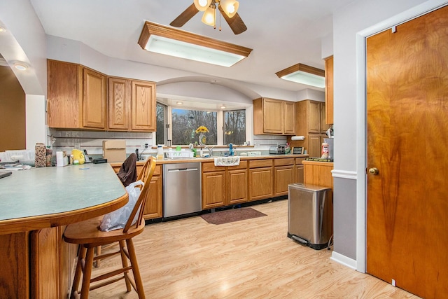 kitchen with backsplash, ceiling fan, dishwasher, and light hardwood / wood-style flooring