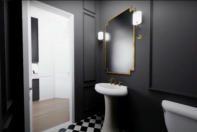 bathroom featuring toilet and wood-type flooring