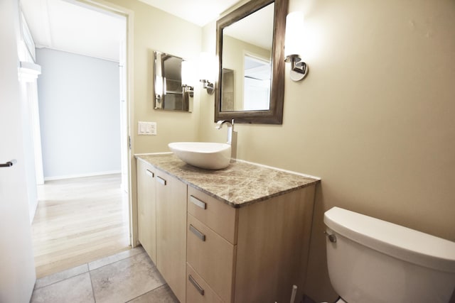 bathroom with toilet, vanity, and tile patterned flooring