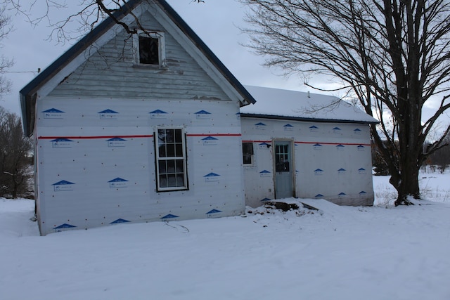 view of snow covered rear of property