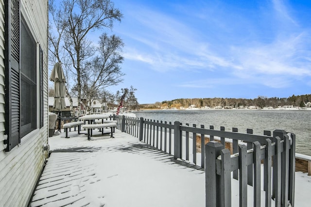 snow covered deck featuring a water view