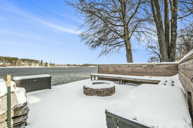 yard covered in snow featuring a water view