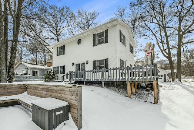 snow covered house with a wooden deck