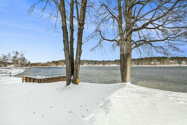 snowy yard featuring a water view