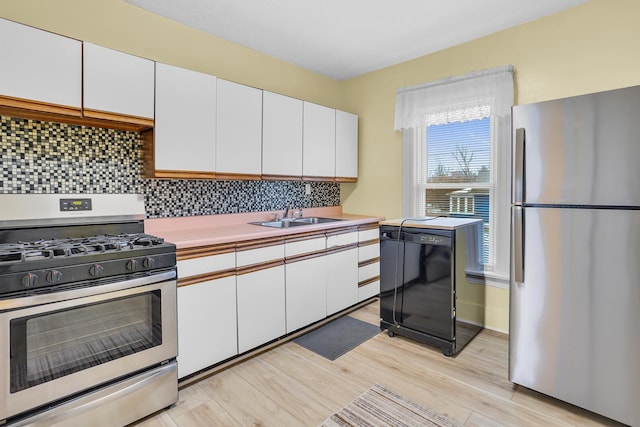 kitchen with white cabinetry, sink, stainless steel appliances, tasteful backsplash, and light hardwood / wood-style flooring