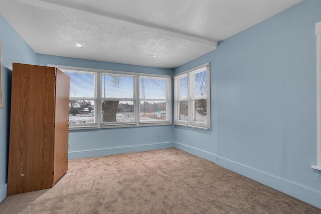 carpeted empty room featuring a textured ceiling