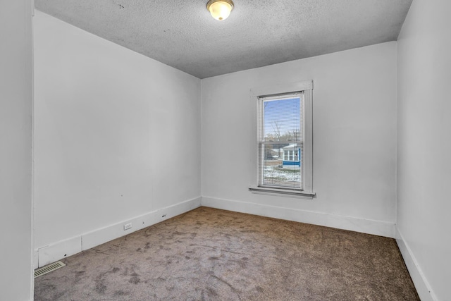 carpeted spare room with a textured ceiling