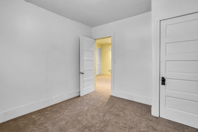 carpeted empty room with a textured ceiling